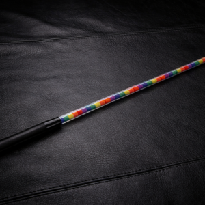 Lexan rainbow performance cane resting on black leather surface with transparent shaft and colorful core