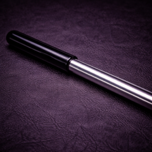 stainless steel impact cane with rubber grip handle on leather background
