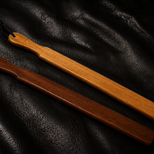 Handcrafted Long Hardwood Paddles in Clear Oak and Cherry Oak displayed on a premium black leather background.